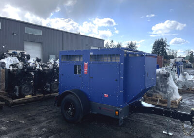blue enclosed diesel driven pump sitting outside the warehouse