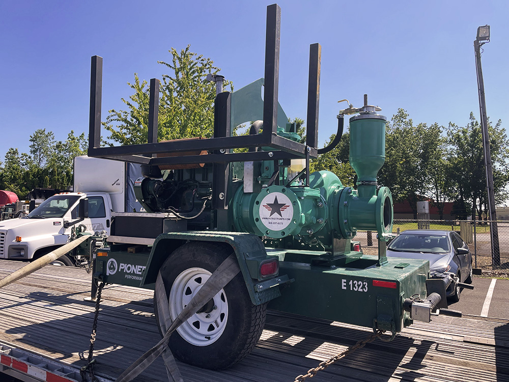A green refurbished pump on a trailer outside